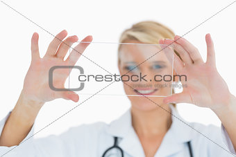 Smiling doctor holding up clear pane
