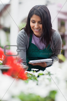 Worker looking at the flowers and making notes