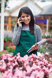 Black-haired woman calling while doing stocktaking