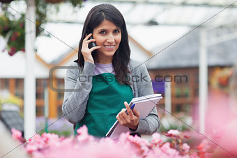 Employee talking on phone while checking flowers