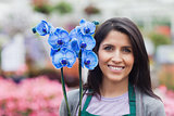Brunette garden center worker holding a flower