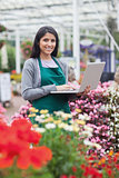 Brunette typing on the laptop in the garden centre