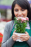 Florist holding flower while smelling it