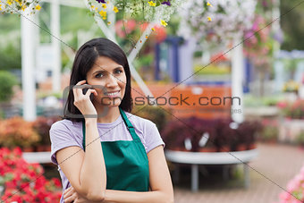 Woman working in garden center making a call