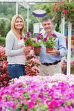 Couple holding purple plants and smiling