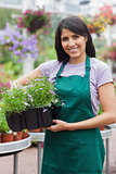 Smiling assistant carrying flower boxes
