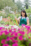 Woman having fun while watering plants with hose