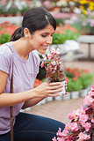 Woman raising a flower while smelling