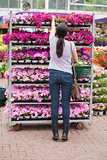 Woman taking flower from the shelves