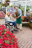 Smiling woman in wheelchair buying a flower