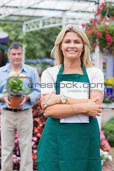 Customer holding a flower with woman holding a notepad