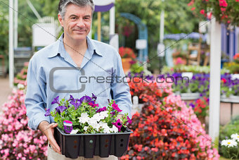 Man carrying boxes outside in garden center