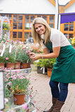 Woman working in garden center checking the plants
