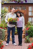 Smiling couple holding tray of plants