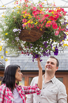 Couple touching the hanging flower basket