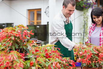 Customer and garden center worker discussing plants