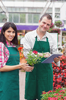 Happy workers with tablet pc in garden center