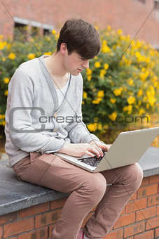 Young man using laptop outside