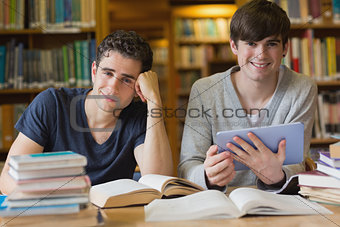 Young men looking up from studying in library