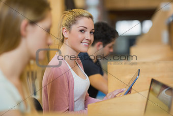 Student with tablet pc looking up from studying