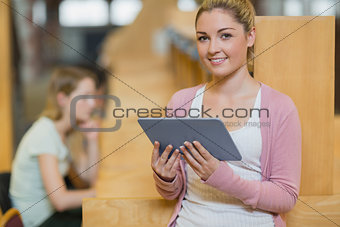 Woman standing in library with tablet pc