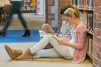 Students sitting in front of a bookshelf