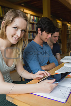 Woman holding a tablet pc sitting at the library