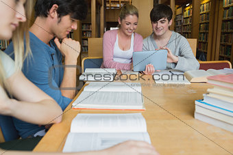 Students in the library studying with two using tablet pc