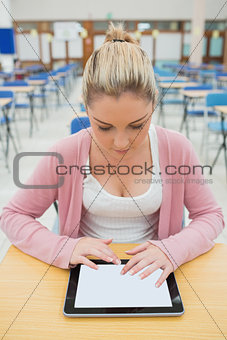 Woman in empty exam hall using tablet pc