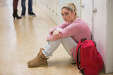 Student sitting against lockers