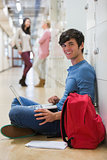 Man sitting on the floor at the hallway smiling