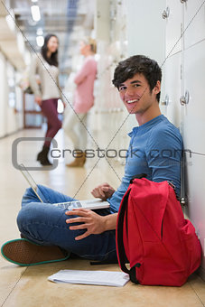 Man sitting on the floor at the hallway smiling