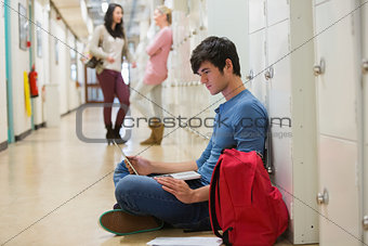 Concentrated student sitting on the floor