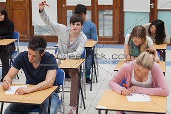 Boy raising hand during exam