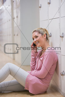 Woman sitting on the floor phoning