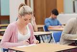 Woman writing note in classroom