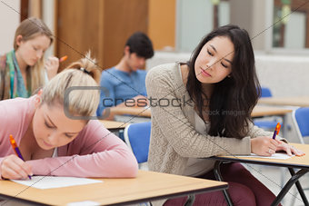 Girl copying another students work in exam