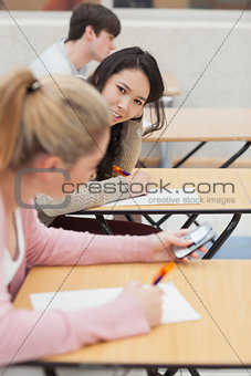 Women talking and texting during class