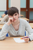 Student sitting at table thinking