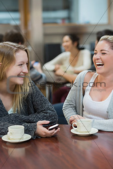 Women sitting at the college coffee shop while laughing