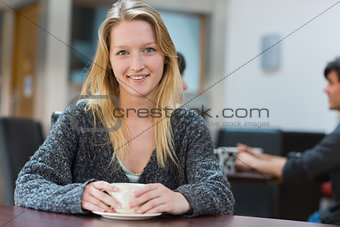 Woman sitting drinking a cup of coffee