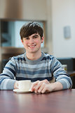 Man sitting at the table drinking coffee in college cafe