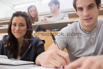 Students sitting at the desk smiling