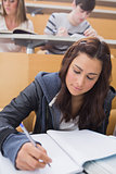 Woman sitting at the lecture hall writing