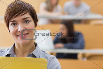 Teacher standing at the lecture hall smiling