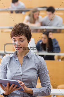 Teacher standing holding a tablet computer