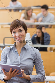 Woman standing holding a tablet computer smiling