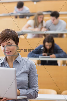 Lecturer standing holding a laptop