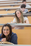 Student sitting reading a book in lecture hall
