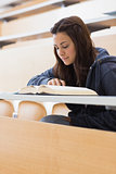 Girl reading a book at the lecture hall